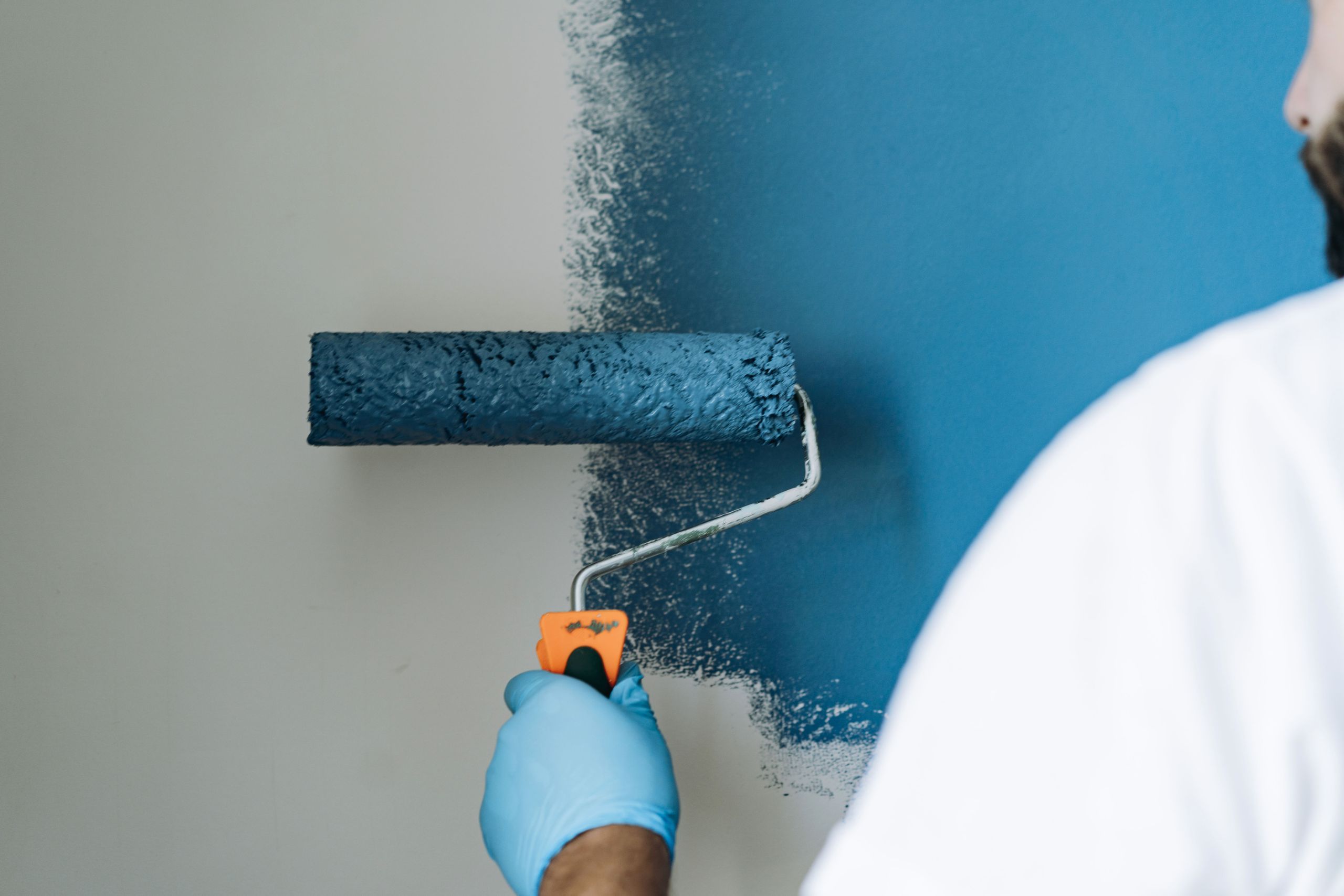 Maler streicht eine Wand mit der Farbrolle